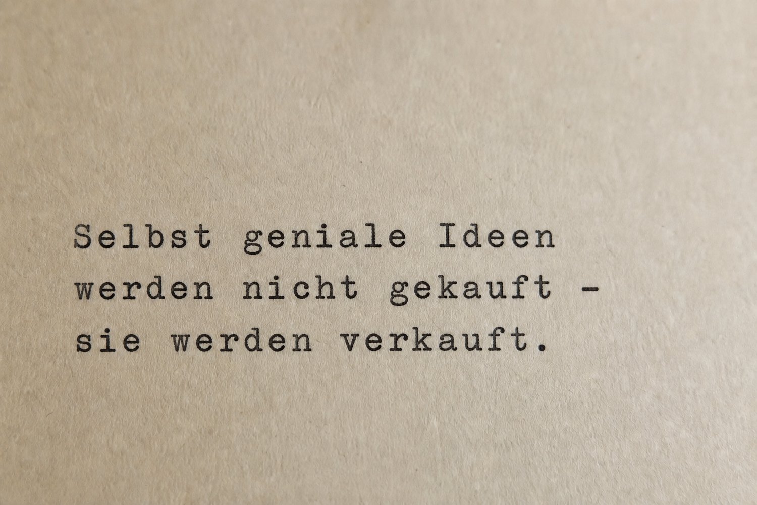 Getippter Satz auf Papier: Selbst geniale Ideen werden nicht gekauft, sie werden verkauft.
